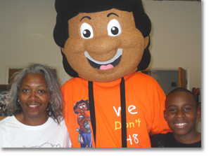 Mrs. Johnson, Founder, and  Mop Top surprise a young Mop Top Shop Camper to a full-scholarship to attend camp